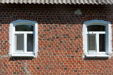 Tuğla kaplı pencereli eski tuğla duvar.