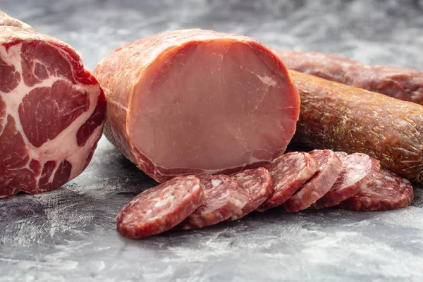 Variété de produits carnés, y compris jambon et saucisses. — Photo