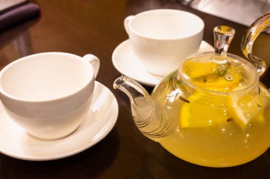 Limon dilimleri ve sıcak çay bir su ısıtıcısı ile yeşil çay bir Fincan 