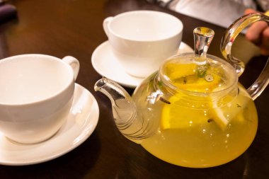 Limon dilimleri ve sıcak çay bir su ısıtıcısı ile yeşil çay bir Fincan 