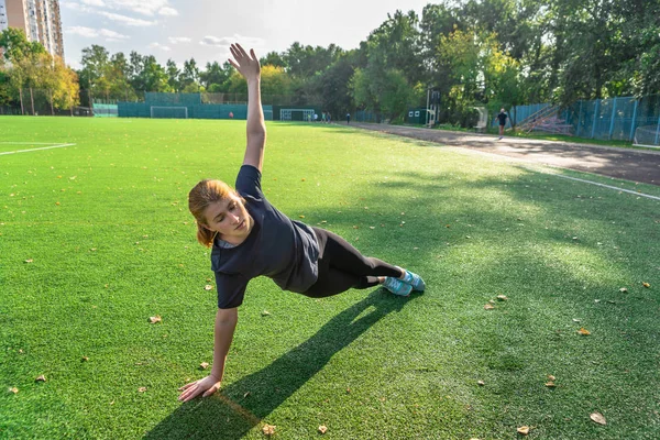 Foto de mulher esportiva envolvida na aptidão no gramado — Fotografia de Stock