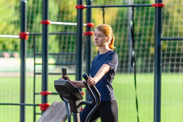 Spor elbiseli sağlıklı bir kadın açık havada egzersiz yapıyor.