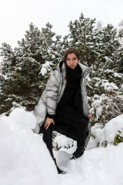 Dışarıda, karlı havada mutlu genç bir kadının hayat tarzı portresi.