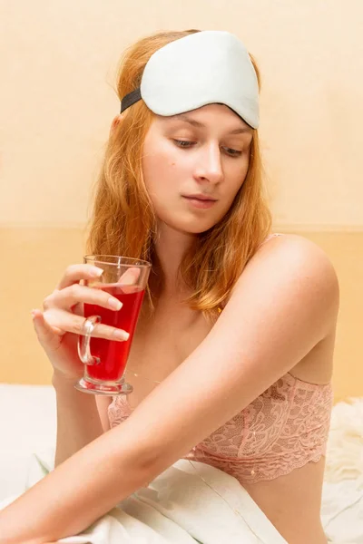 Mujer de pelo rojo sosteniendo un vaso de vino con especias usando ma dormida — Foto de Stock
