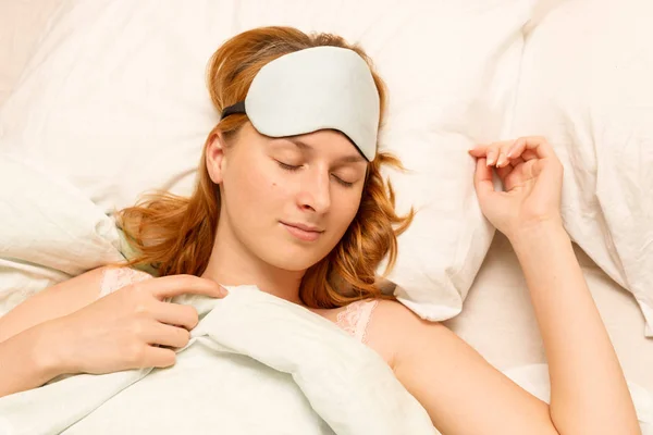 Una joven que duerme con una máscara que cubre los ojos . — Foto de Stock