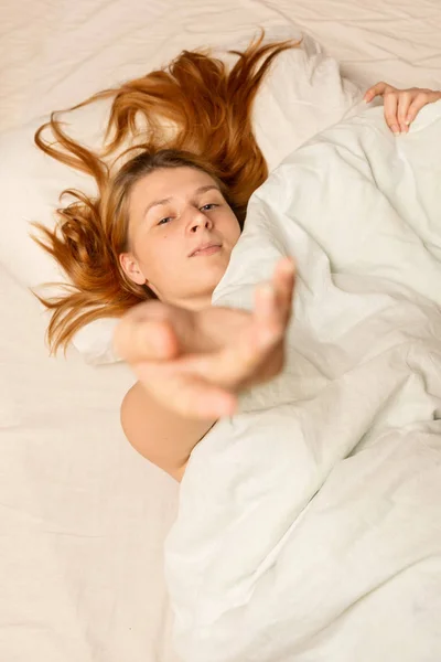 家の毛布の下に寝そべっている若い女性の肖像画 — ストック写真