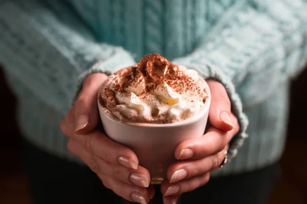 Frau hält Becher mit Kakaogetränk mit Schlagsahne in der Hand — Stockfoto