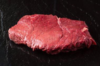 Taze çiğ et. Siyah taş kaplamalı taze kırmızı et parçası..