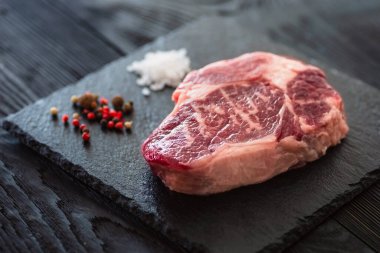 Taş tahtada taze çiğ ana Angus bifteği Striploin, Rib Eye. Karanlık bir arka planda