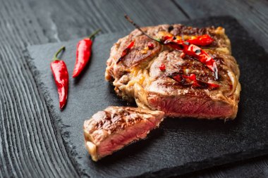 Kırmızı biber ve baharatlı, orta pişmiş ızgara biftek, koyu kırsal ahşap arka plan, üst manzara, yazı için yer.