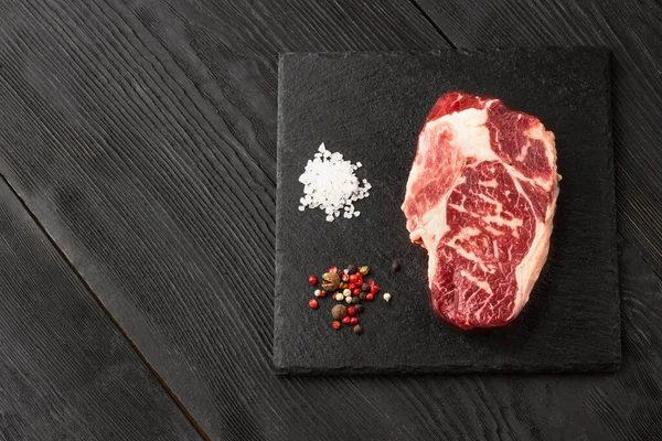 石板上新鲜的原生黑安格斯牛肉蒸肉 条斑蛋白 顶部视图 黑暗的背景下 — 图库照片
