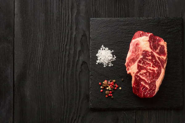 石板上新鲜的原生黑安格斯牛肉蒸肉 条斑蛋白 顶部视图 黑暗的背景下 — 图库照片