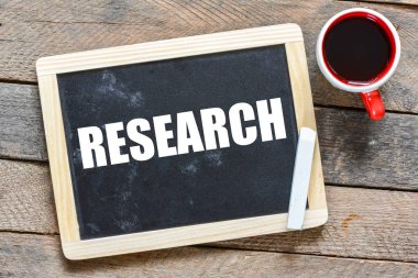 Yazı tahtası ahşap arka plan üzerinde beyaz tebeşir ile el yazısı araştırma