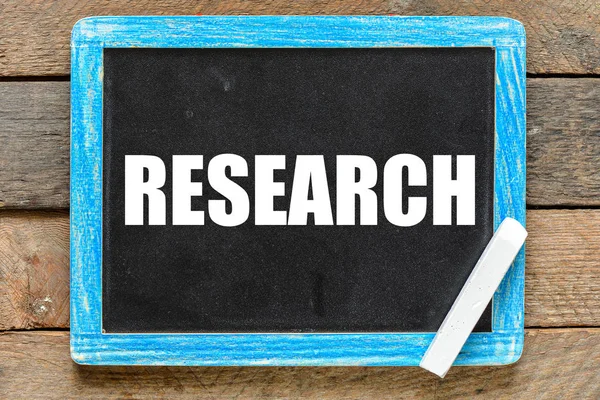 Yazı tahtası ahşap arka plan üzerinde beyaz tebeşir ile el yazısı araştırma