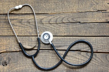 Siyah stetoskop. Ahşap arka plan üzerinde siyah stetoskop.