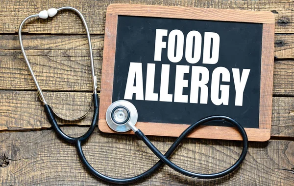 木材の背景に黒板に白チョークで手書き食物アレルギー — ストック写真