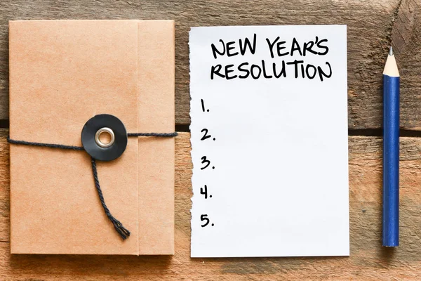 Bir defter, ahşap arka plan üzerinde yeni yıl çözünürlük 