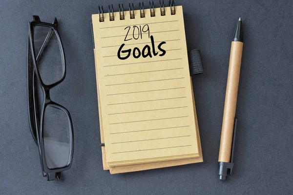 2019 Goals Handwritten Notebook Eyeglasses Pen Grey Background — Stock Photo, Image