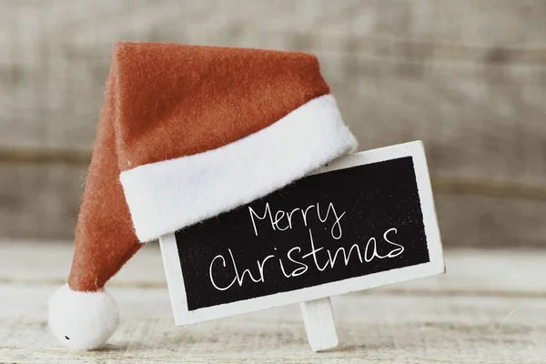 Frohe Weihnachten Text Auf Kleiner Tafel Mit Weihnachtsmütze Geschrieben — Stockfoto