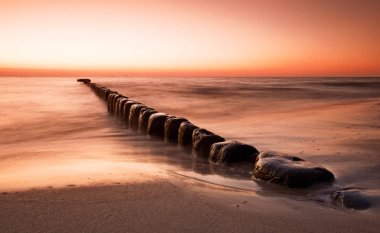 satır kumsalda dramatik gündoğumu ile arka plan arasında doğal taş görünümünü yerleştirilir