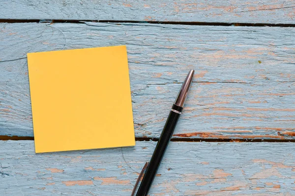 ahşap arka planda boş not defteri ve kalem, üst görünüm 