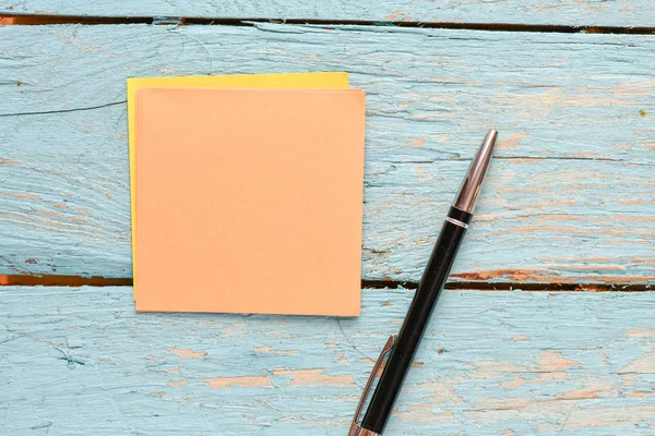 ahşap arka planda boş not defteri ve kalem, üst görünüm 