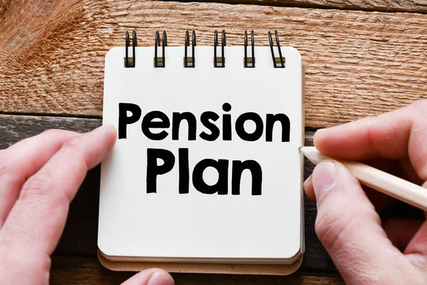 Notepad with text pension plan in human hands