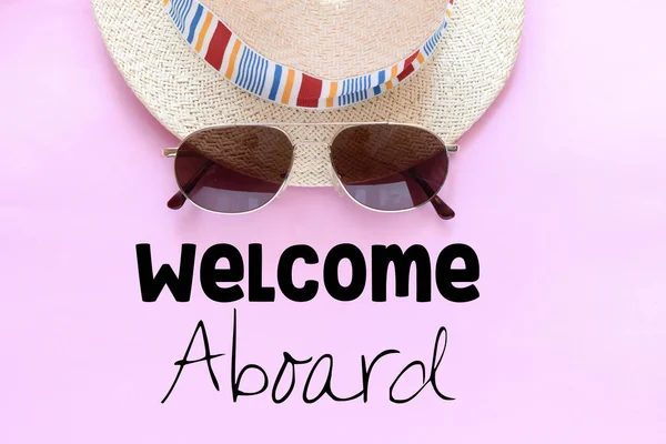 Willkommen Ausland Schriftzug Mit Sonnenbrille Und Hut Auf Rosa Hintergrund — Stockfoto