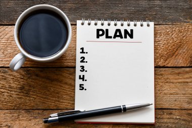not defteri, kalem ve ahşap arka plan üzerinde kahve fincan boş Plan kelimeüst görünümü 