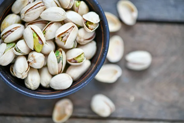 Ahşap masa üzerinde antep fıstığı ile fincan Closeup görünümü