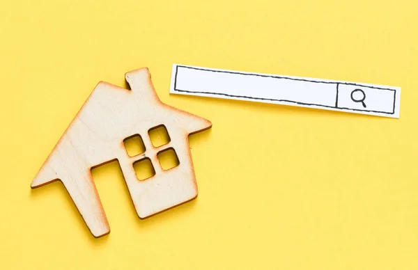 Wooden house with search line on yellow table