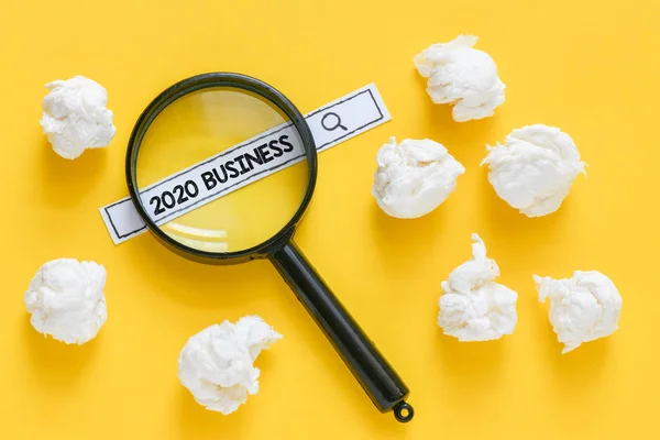 2020年のビジネステキスト 紙片で黄色の机の上で顧客を検索する虫眼鏡 — ストック写真
