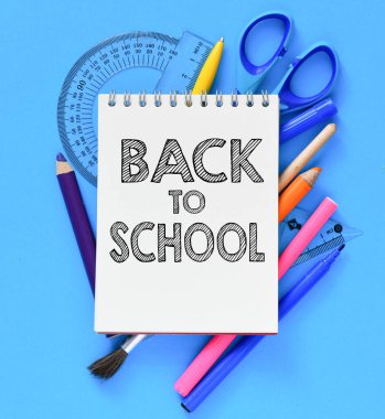 mavi arka plan üzerinde defter ve okul malzemeleri okul kitabesi geri 