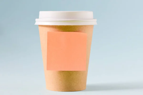 Coffee to go and blank sticky note on grey background
