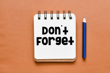 Metin metinli not defteri, kopya alanı olan kahverengi arka planda unutmayın