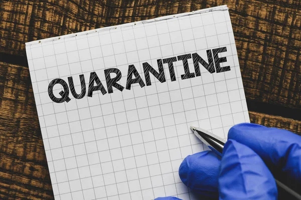 QUARANTINE text written on a piece of paper. Concept photography.