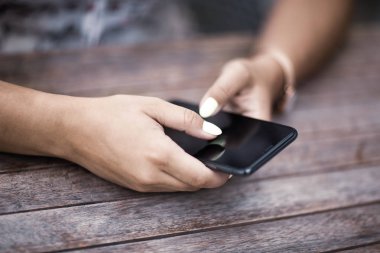 Cep telefonunu kullanarak eller kadın yakın çekim. Açık.