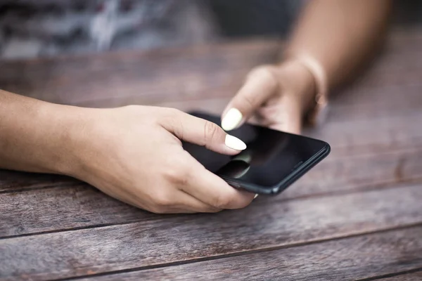 Fechar as mãos mulher usando seu telefone celular. Ao ar livre . — Fotografia de Stock