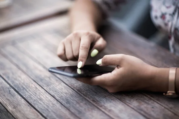 Fechar as mãos mulher usando seu telefone celular. Ao ar livre . — Fotografia de Stock