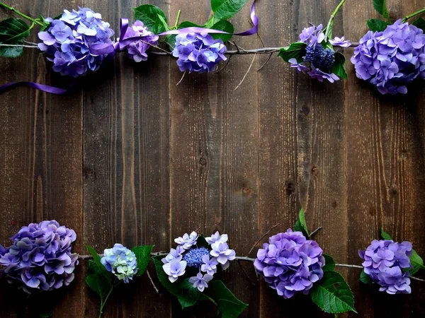 Purple hydrangea frame.on the black wooden background