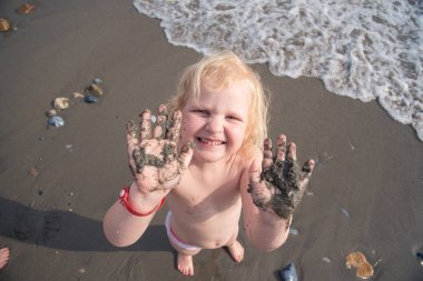 Beyaz kız elleri kirli deniz kum gösterir