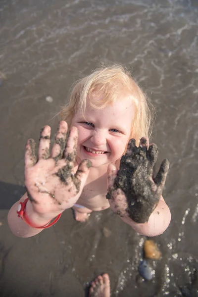 Kız elleri kirli deniz kum gösterir