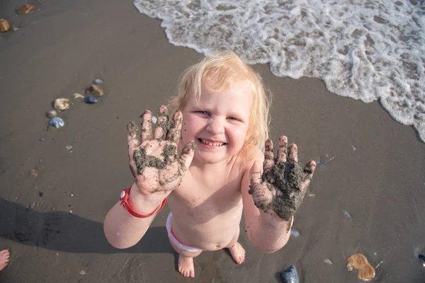 Beyaz kız elleri kirli deniz kum gösterir