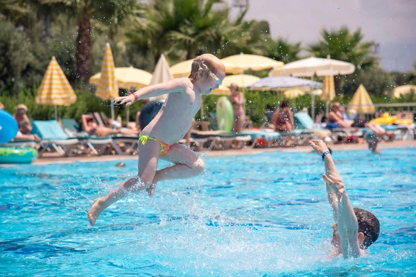 bir beyaz kız havuzun üzerinde atlama yüksek