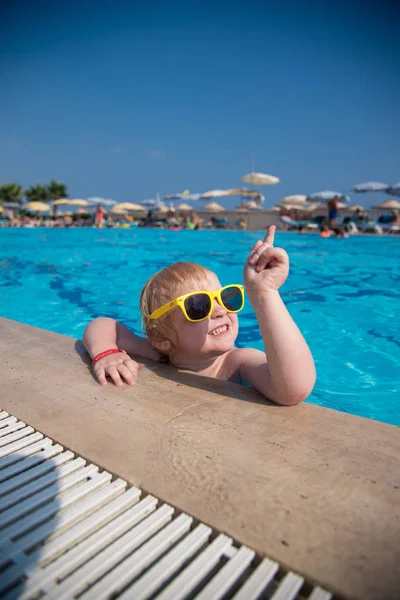 havuzda küçük kız onun parmağını üst gösterir.