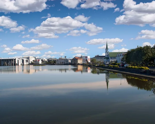 Houses and buildings reflected in lake Tjornin in Reykjavik Iceland