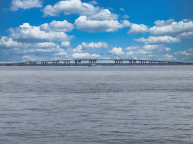 Three Mile Köprüsü Pensacola Körfezi, Florida boyunca uzanıyor. Kabarık beyaz bulutlarla benekli bir gökyüzünün altında..