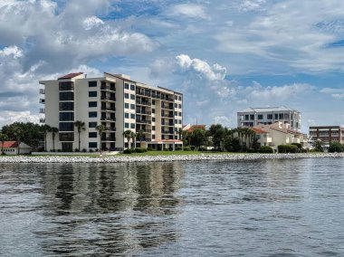Modern rıhtım konutları Pensacola Körfezi, Florida 'nın kayalık kıyıları, parlak balkonları ve cam cepheleri aşağıdaki sakin, güneşli sulara yansıyor..