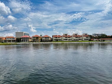 Modern rıhtım konutları Pensacola Körfezi, Florida 'nın kayalık kıyıları, parlak balkonları ve cam cepheleri aşağıdaki sakin, güneşli sulara yansıyor..