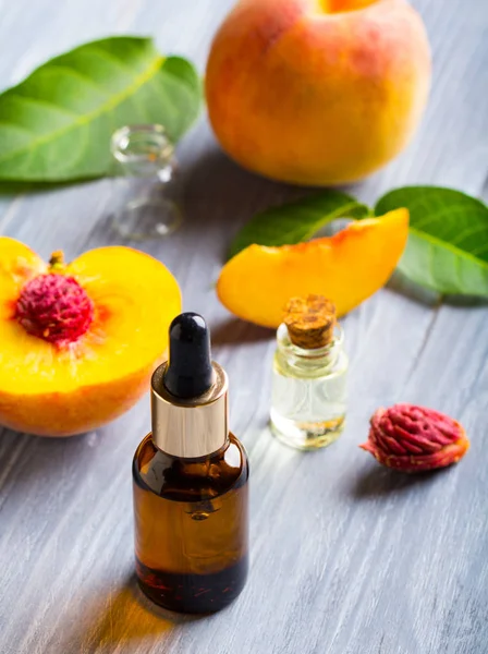 Peach oil cosmetics medicine health nature glass vial wooden background
